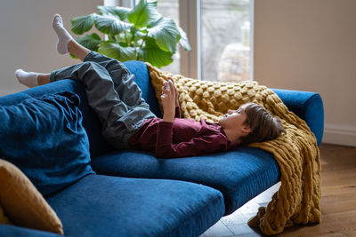 Young woman sitting on sofa at home