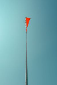 Low angle view of flag against clear blue sky