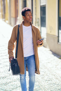 Full length of young man walking on street in city