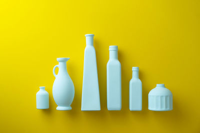 Various bottles on table against yellow background