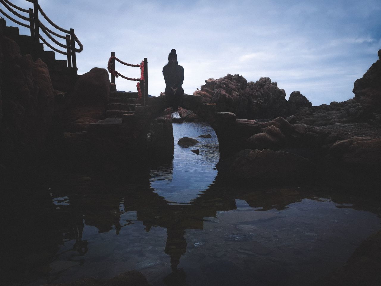 SILHOUETTE PEOPLE STANDING ON ROCK BY SEA