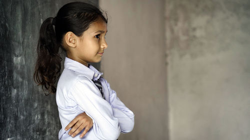 Young woman standing against wall