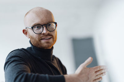 Businessman wearing eyeglasses gesturing in office