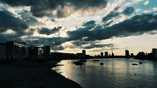 Cityscape against cloudy sky at dusk