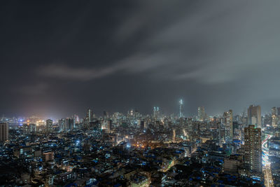 High angle view of illuminated buildings against sky at night