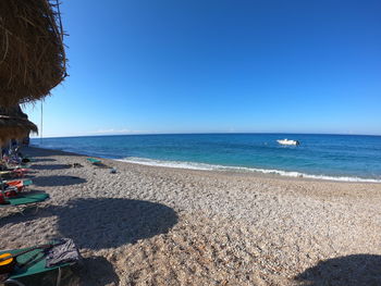 Scenic view of beach against clear blue sky