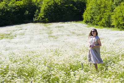 Women with dress in field of daisy flowers during sunlight