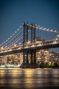 View of suspension bridge in city at night