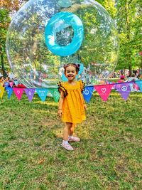 Full length of a smiling girl standing in park