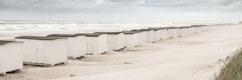 Wooden posts on beach against sky