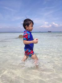 Full length of boy on beach against sky