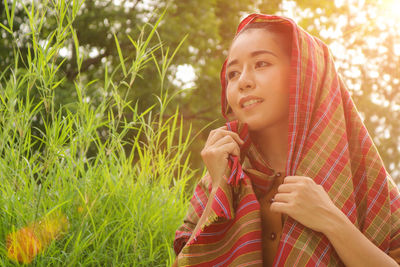 Woman covering head with textile on field