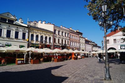 Buildings in city against clear blue sky