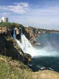 Scenic view of waterfall against sky