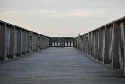 Empty footpath amidst buildings against sky