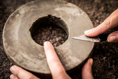 Cropped hands of man holding metal and knife
