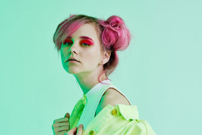 Portrait of young woman against blue background