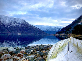 Scenic view of lake by mountains against sky