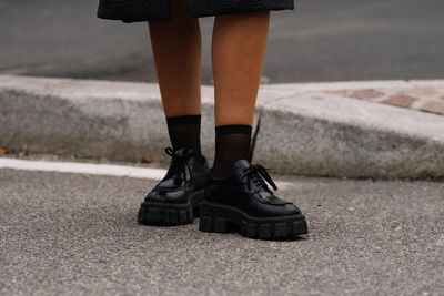 Low section of woman walking on road