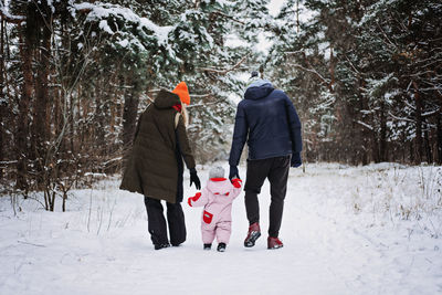 Outdoor family activities for happy winter holidays. happy father and mother playing with little