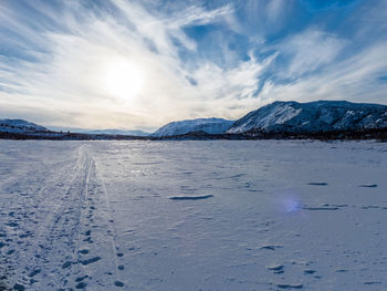 Scenic view of frozen lake against sky during sunset