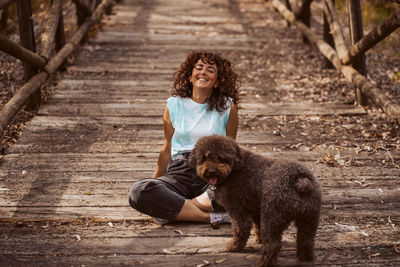 Side view of young woman with dogs on boardwalk