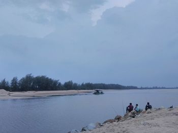 People on beach against sky