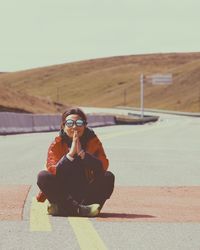 Portrait of young woman sitting on sunglasses