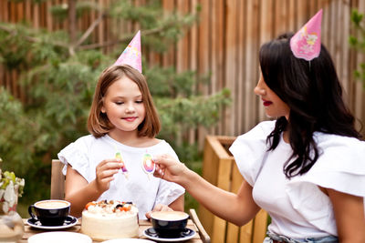 Mother and daughter sitting outdoors