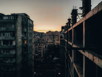 High angle view of street amidst buildings in city at sunset