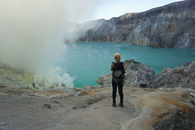 Tourist taking pictures at the bottom of ijen crater.