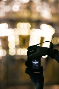 Close-up of hand holding illuminated camera