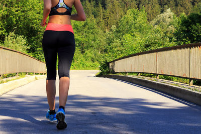 Rear view of woman standing on road