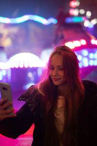 Young woman using mobile phone at night