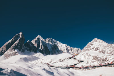 Ascenic view of snowcapped mountains against clear blue sky