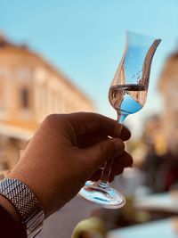 Close-up of person holding wineglass outdoors