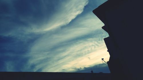 Low angle view of silhouette buildings against sky at sunset