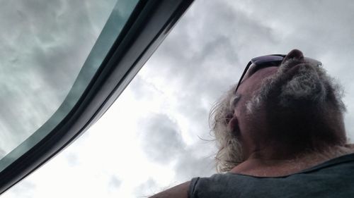 Low angle view of man looking through window
