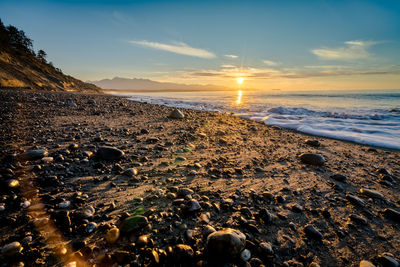 Scenic view of beach against sky during sunset