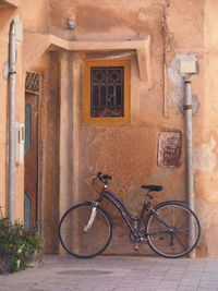 Bicycle parked on wall of building