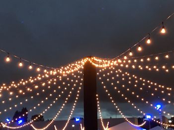 Low angle view of illuminated suspension bridge at night