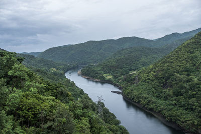 Scenic view of river amidst mountains against sky