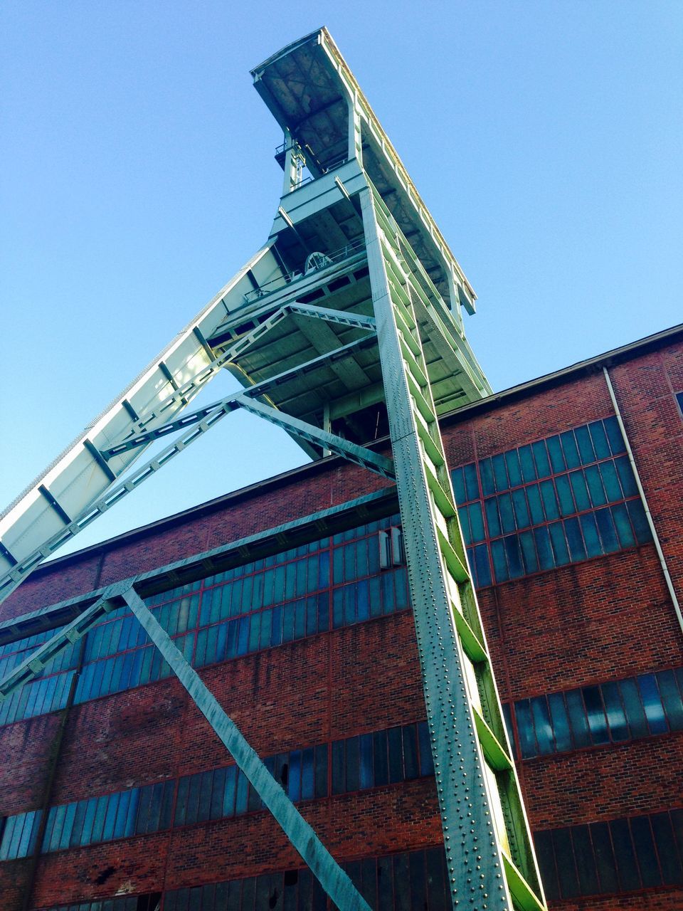 architecture, built structure, building exterior, clear sky, low angle view, tower, tall - high, blue, travel destinations, city, day, metal, famous place, sunlight, architectural feature, outdoors, no people, tall, sky, history