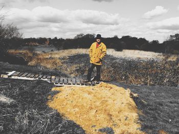 Man standing on boardwalk in forest