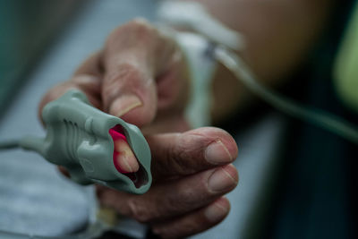 Cropped hand of patient wearing iv drip in hospital