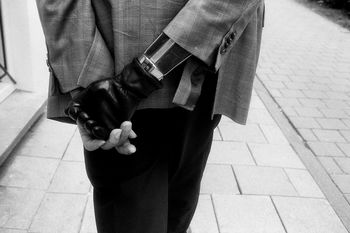 Midsection of man with prosthetic hand walking on footpath