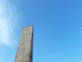 Low angle view of factory against blue sky