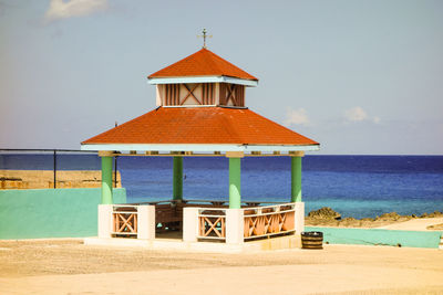 Lifeguard hut on beach against sky