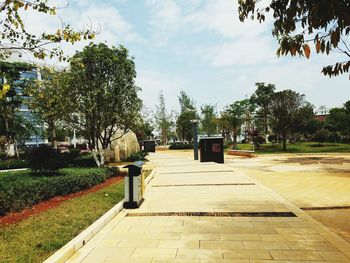 Footpath in park against sky