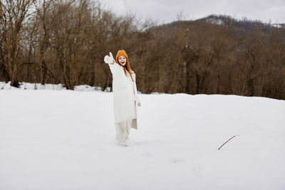 Rear view of woman standing on snow covered field